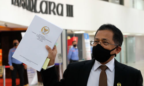 <p>Sekretaris Jenderal DPR RI, Indra Iskandar menunjukkan berkas naskah final Undang-Undang Cipta Kerja yang akan diantarkan kepada Presiden Jokowi dari Gedung DPR, Komplek Parlemen, Senayan, Jakarta, Rabu, 14 Oktober 2020. Dewan Perwakilan Rakyat (DPR) melalui sekretaris jenderal secara resmi menyerahkan draf final Omnibus Law UU Cipta Kerja kepada Presiden Joko Widodo selaku kepala pemerintahan. Nantinya, berkas Omnibus Law UU Cipta Kerja ditandatangani Jokowi sebelum diundangkan oleh Menkumham Yasonna Laoly. DPR memastikan bahwa naskah final UU Cipta Kerja yang akan diserahkan ke Presiden Jokowi esok total berjumlah 812 halaman. Foto: Ismail Pohan/TrenAsia</p>
