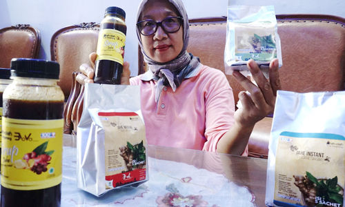 <p>Pekerja menunjukkan produk olahan jahe di industri rumahan kawasan Bugel, Kota Tangerang, Banten, Jum’at 2 Oktober 2020. Produk Usaha Mikro, Kecil, Menengah (UMKM) olahan jahe yang dijadikan sirup, serbuk dan permen jahe ini mendapatkan berkah ditengah pandemi, produksi dan penjualan meningkat tajam. Produk berbahan jahe menjadi tren dikalangan warga ditengah wabah corona. Warga mencari sirup olahan jahe untuk menjaga stamina  dan imunitas tubuh disaat pandemi Covid-19. Produk olahan jahe ditempat ini dijual dari harga Rp3 ribu hingga Rp35 ribu per buah. Foto : Panji Asmoro/TrenAsia</p>
