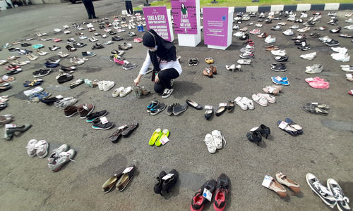 <p>Pegiat komnas perempuan memegang sepatu saat aksi diam ‘500 Langkah Awal Sahkan Rancangan Undang-Undang Penghapusan Kekerasan Seksual (RUU PKS) di depan gedung DPR, Jakarta, Rabu, 25 November 2020. Foto: Ismail Pohan/TrenAsia</p>
