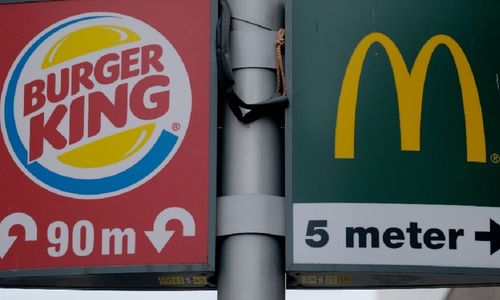 <p>Ilustrasi restoran siap saji Burger King dan McDonald’s / Getty Image</p>