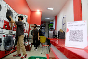 <p>Pekerja memasukkan pakaian kedalam mesin cuci di gerai jasa layanan laundry di kawasan Kemang, Jakarta, Selasa, 24 November 2020. Foto: Ismail Pohan/TrenAsia</p>
