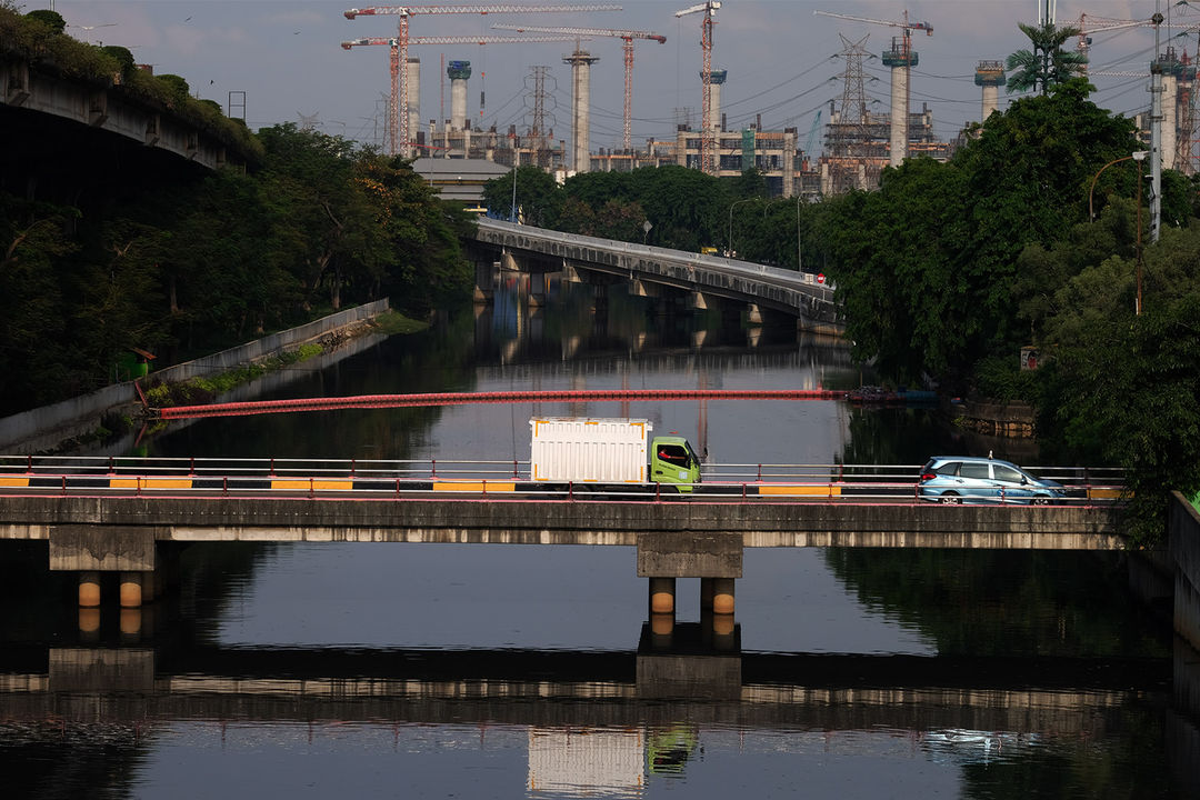 <p>Sejumlah kendaraan melintas di ruas jalan berlatar belakang pembangunan Jakarta Internasional Stadium dari kawasan Kemayoran, Jakarta, Selasa, 3 November 2020. foto: Ismail Pohan/TrenAsia</p>
