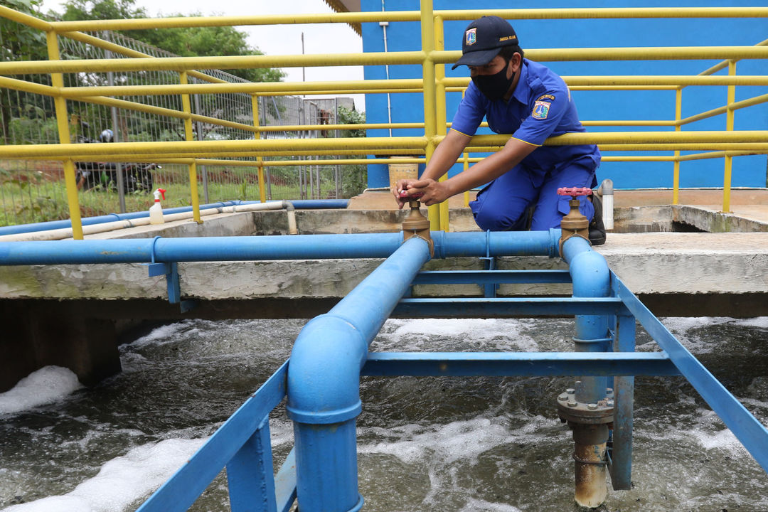 Seorang petugas memeriksa pipa saluran air. Gubernur Kaltim Isran Noor menyebut capaian akses layanan air layak, telah melebihi target.Foto: Ismail Pohan/TrenAsia</p>
