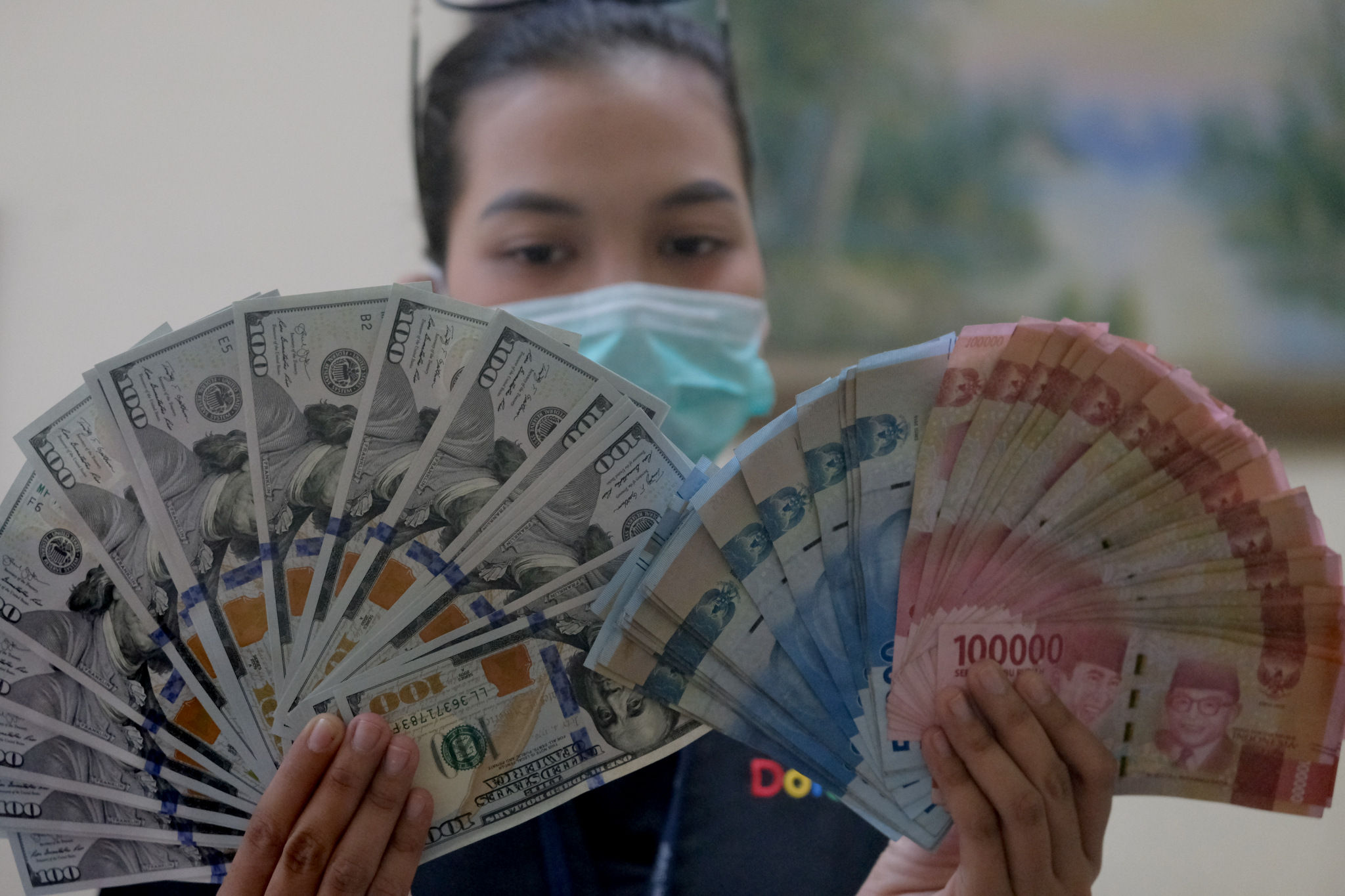 <p>Karyawati menunjukkan mata uang Rupiah dan Dolar di salah satu tempat penukaran uang atau Money Changer di kawasan Melawai, Jakarta, Senin, 9 November 2020. Foto: Ismail Pohan/TrenAsia</p>
