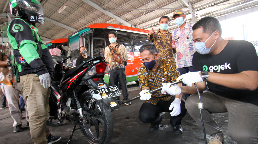 <p>Wakil Kepala Dinas Lingkungan Hidup Provinsi DKI Jakarta, Syaripudin (kedua kanan) dan VP Public Policy and Government Relations Gojek, Gautama Adi Kusuma (kanan) melakukan uji emisi pada kendaraan mitra GoRide, di halaman kantor Dinas Lingkungan Hidup Provinsi DKI Jakarta, Kamis, 19 November 2020. Foto: Panji Asmoro/TrenAsia</p>
