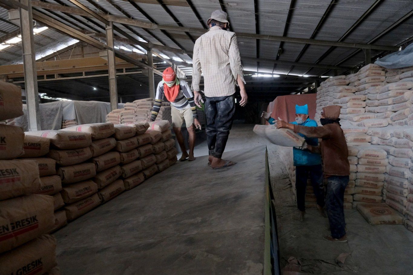 Pekerja melakukan bongkar muat semen di salah satu gudang distributor semen di Jalan Panjang Arteri Kelapa Dua Raya, Jakarta, Selasa, 1 Desember 2020. Foto: Ismail Pohan/TrenAsia