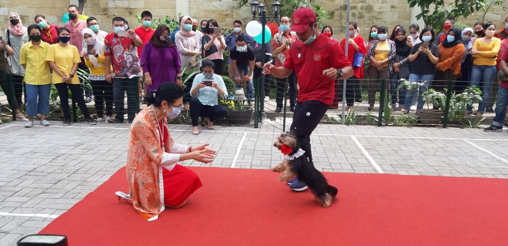 Theresia rela jongkok untuk menyambut Nala yang akan memberinya sekuntum bunga mawar.