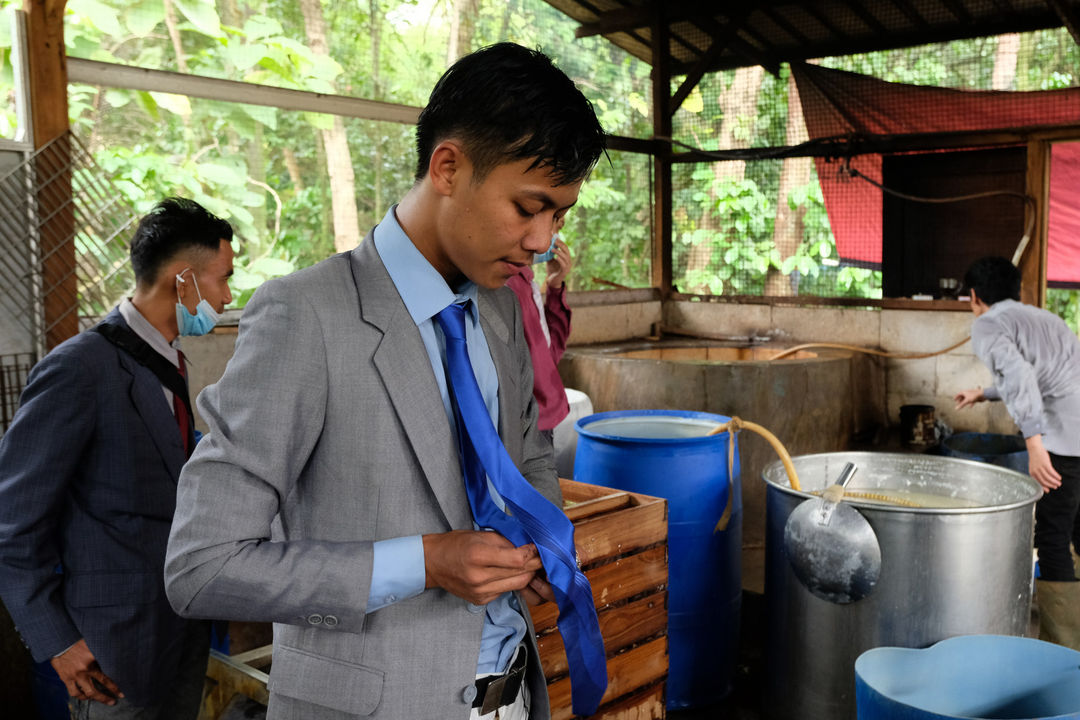 <p>Pekerja mengenakan busana formil jas, kemeja, dan berdasi layaknya pekerja kantoran bersiap sebelum memproduksi tahu di industri rumahan Usaha Mikro Kecil Menengah (UMKM) kawasan Sukaraja, Kabupaten Bogor, Jawa Barat, Senin, 14 Desember 2020. Foto : Ismail Pohan/TrenAsia</p>
