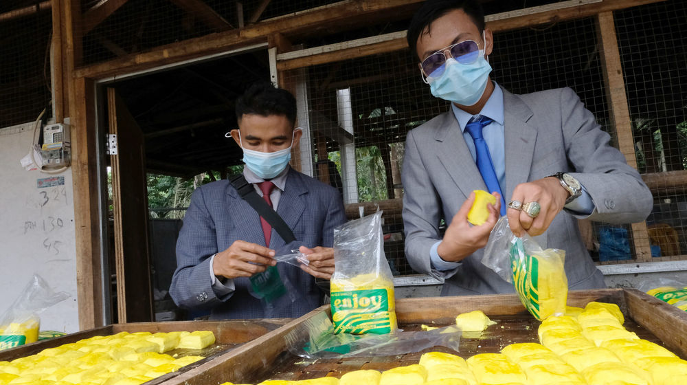 <p>Pekerja mengenakan busana formil jas, kemeja, dan berdasi layaknya pekerja kantoran melakukan pengepakan tahu di industri rumahan Usaha Mikro Kecil Menengah (UMKM) kawasan Sukaraja, Kabupaten Bogor, Jawa Barat, Senin, 14 Desember 2020. Foto : Ismail Pohan/TrenAsia</p>