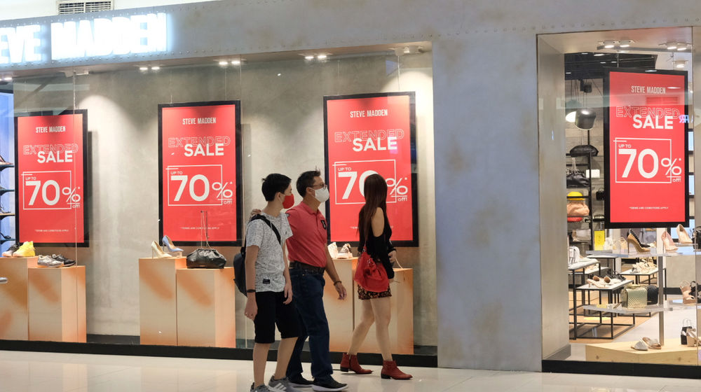 <p>Pengunjung melintas di depan salah satu tenant pusat perbelanjaan yang menggelar diskon belanja Natal dan Tahun Baru di Mal Senayan City, Jakarta, Jum’at, 25 Desember 2020. Foto: Ismail Pohan/TrenAsia</p>