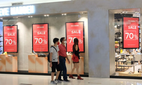 <p>Pengunjung melintas di depan salah satu tenant pusat perbelanjaan yang menggelar diskon belanja Natal dan Tahun Baru di Mal Senayan City, Jakarta, Jum&#8217;at, 25 Desember 2020. Foto: Ismail Pohan/TrenAsia</p>
