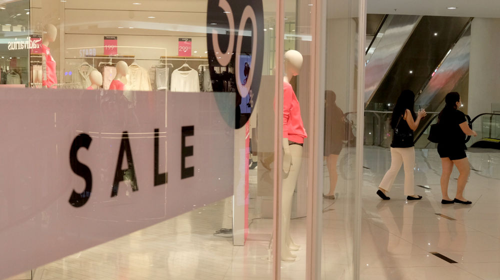 <p>Pengunjung melintas di depan salah satu tenant pusat perbelanjaan yang menggelar diskon belanja Natal dan Tahun Baru di Senayan City, Jakarta, Jum’at, 25 Desember 2020. Foto: Ismail Pohan/TrenAsia</p>
