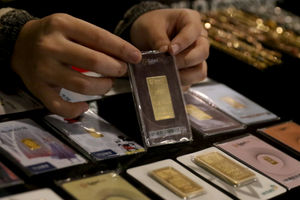 <p>Karyawati menunjukkan emas batangan di gerai emas Pegadaian, Jakarta, Selasa, 15 Desember 2020. Foto: Ismail Pohan/TrenAsia</p>