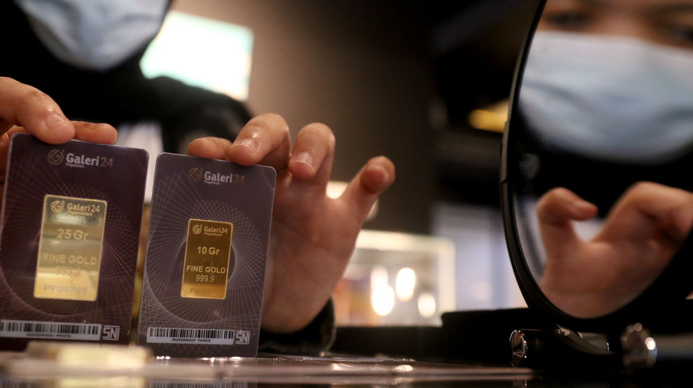 <p>Karyawati menunjukkan emas batangan di gerai emas Pegadaian, Jakarta, Selasa, 15 Desember 2020. Foto: Ismail Pohan/TrenAsia</p>
