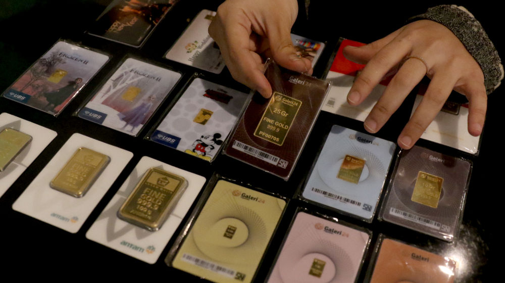 <p>Karyawati menunjukkan emas batangan di gerai emas Pegadaian, Jakarta, Selasa, 15 Desember 2020. Foto: Ismail Pohan/TrenAsia</p>
