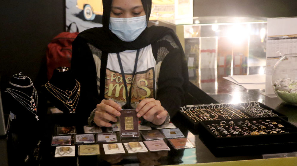 <p>Karyawati menunjukkan emas batangan di gerai emas Pegadaian, Jakarta, Selasa, 15 Desember 2020. Foto: Ismail Pohan/TrenAsia</p>
