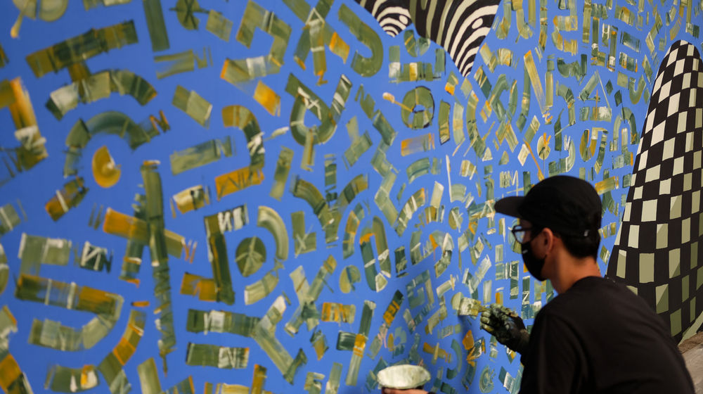 <p>Seniman dari komunitas kreatif Converse All Star membuat mural di tembok luar Institut Prancis Indonesia (IFI), di Jalan Thamrin, Jakarta, Rabu, 2 Desember 2020. Foto: Ismail Pohan/TrenAsia</p>