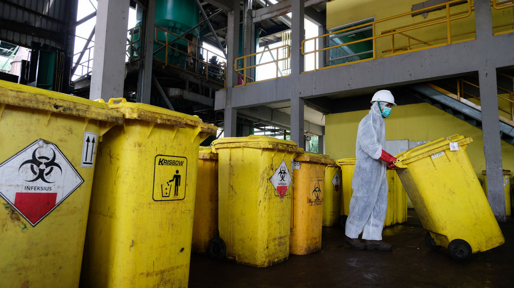 <p>Petugas membawa limbah medis B3 (bahan berbahaya dan beracun) infeksius dengan menggunakan wheleed bin atau wadah beroda di industri pengolahan limbah medis PT. Jasa Medivest, Dawuan Tengah, Kabupaten Karawang, Jawa Barat, Kamis, 10 Desember 2020. Foto: Ismail Pohan/TrenAsia</p>