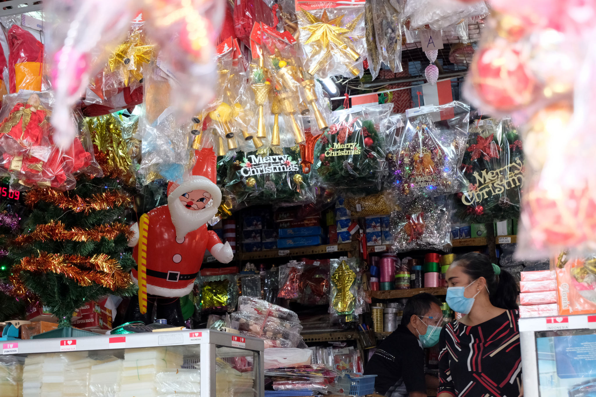 <p>Pekerja menata pernak-pernik aksesoris bernuansa Natal di kios pedagang Pasar Asemka, Jakarta Barat, Rabu, 16 Desember 2020. Foto: Ismail Pohan/TrenAsia</p>

