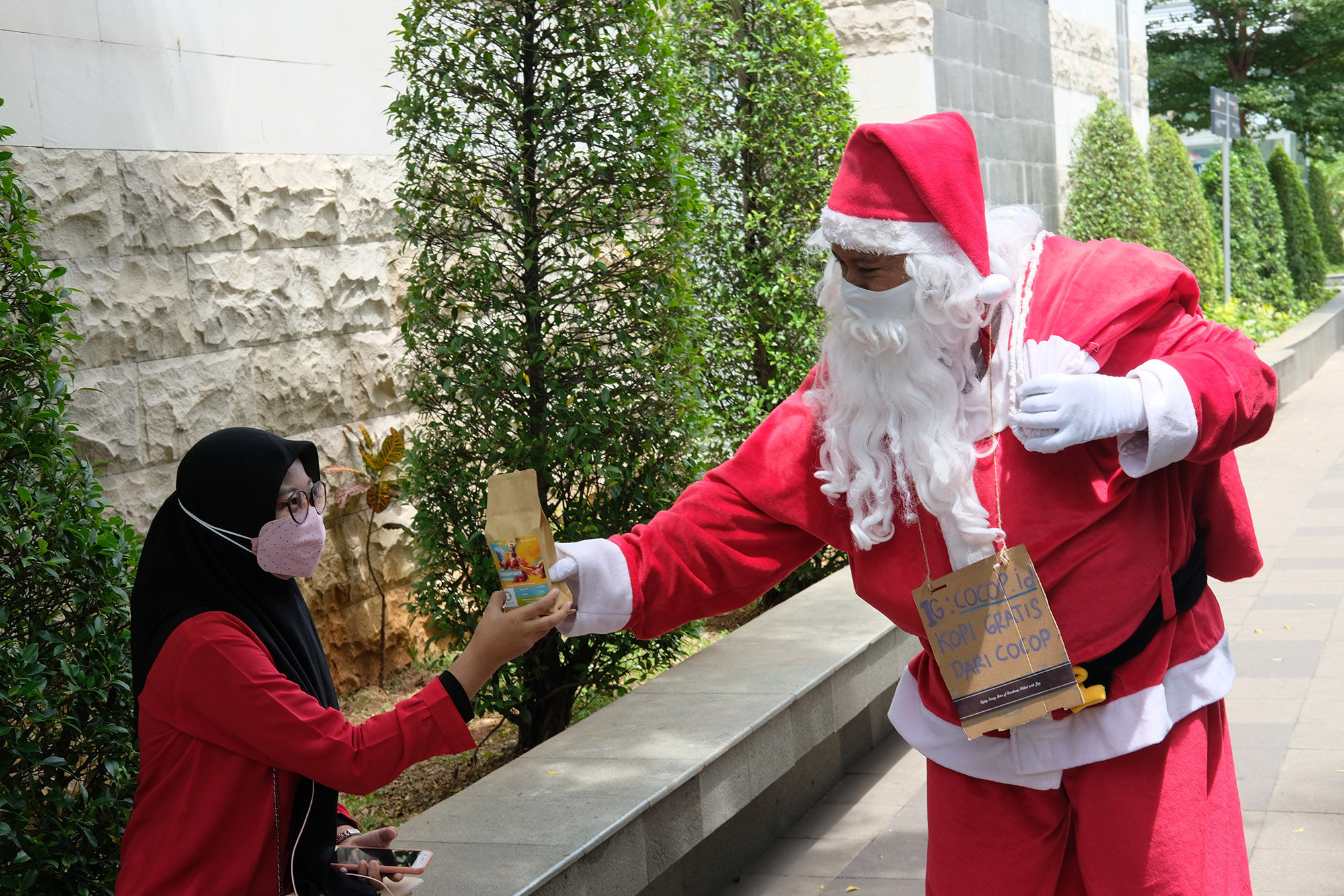 <p>Karyawan dari Cocop.id berkostum Santa Claus membagikan kopi gratis kepada warga, di kawasan Dukuh Atas, Jakarta, Sabtu, 19 Desember 2020. Foto; Ismail Pohan/TrenAsia</p>
