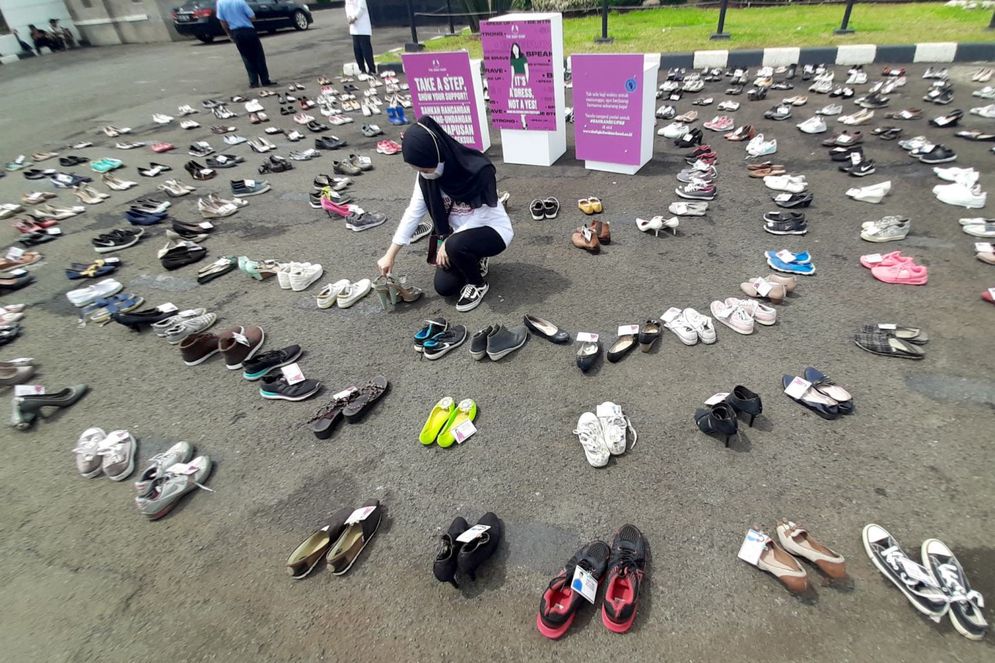 Pegiat komnas perempuan memegang sepatu saat aksi diam '500 Langkah Awal Sahkan Rancangan Undang-Undang Penghapusan Kekerasan Seksual (RUU PKS) di depan gedung DPR, Jakarta, Rabu, 25 November 2020. Foto: Ismail Pohan/TrenAsia