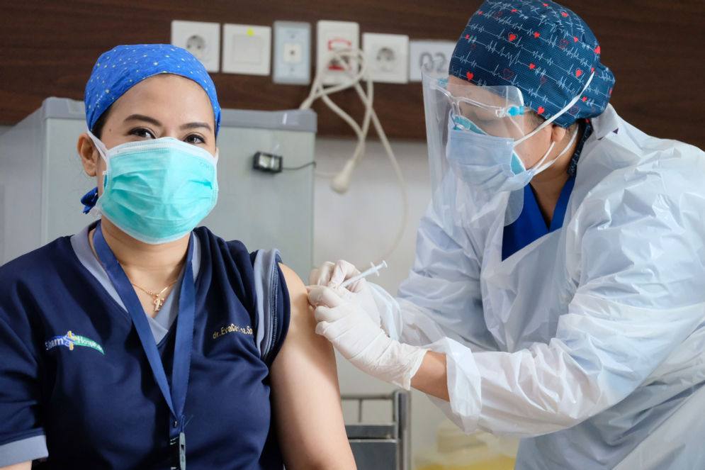 Seorang dokter menjalani penyuntikan vaksin COVID-19 di RS Siloam TB Simatupang, Jakarta, Kamis, 14 Januari 2021.Foto: Ismail Pohan/TrenAsia