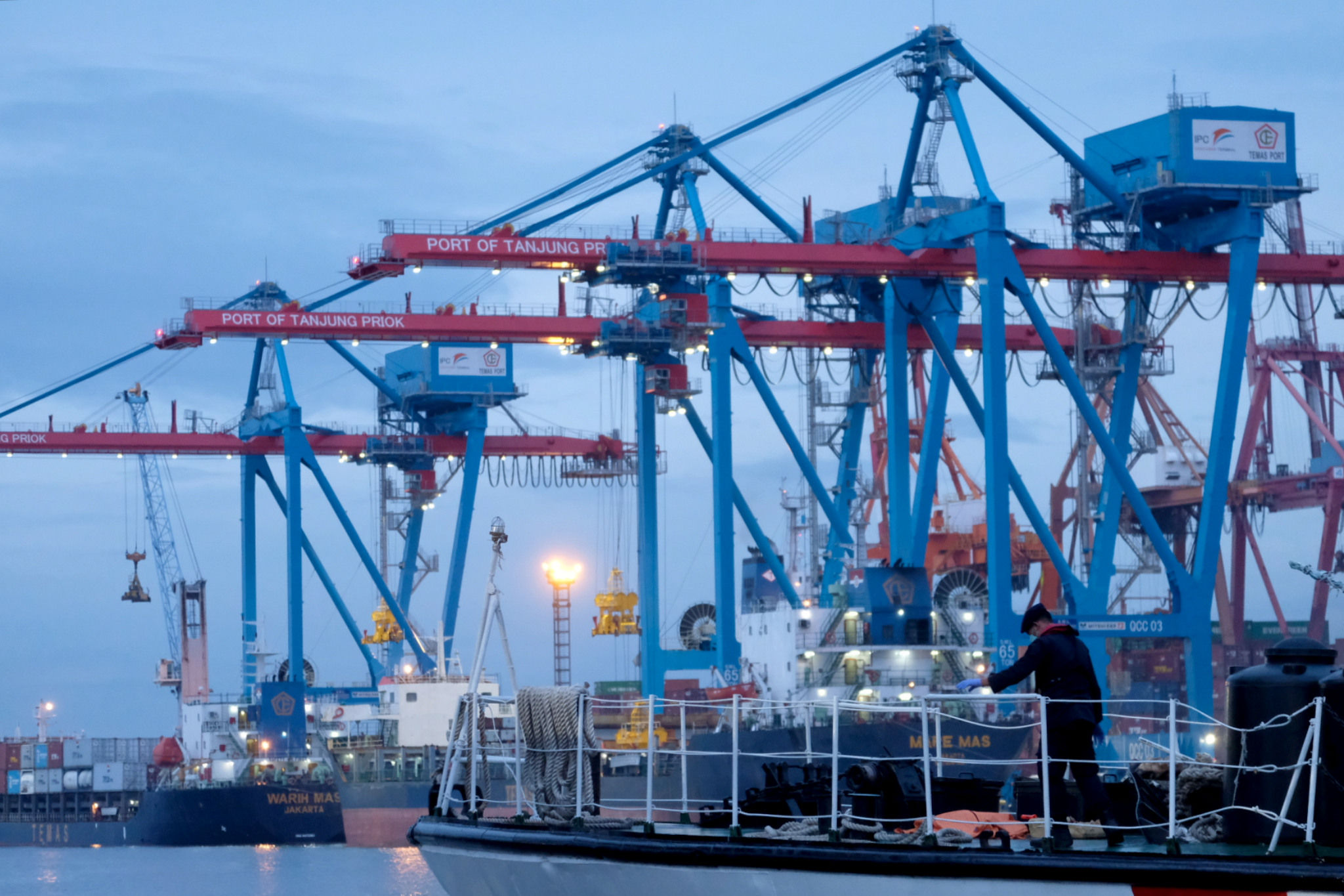 <p>Kapal melintas didekat crane bongkar muat peti kemas di dermaga Pelabuhan Tanjung Priok, Jakarta, Senin, 11 Januari 2021. Foto: Ismail Pohan/TrenAsia</p>
