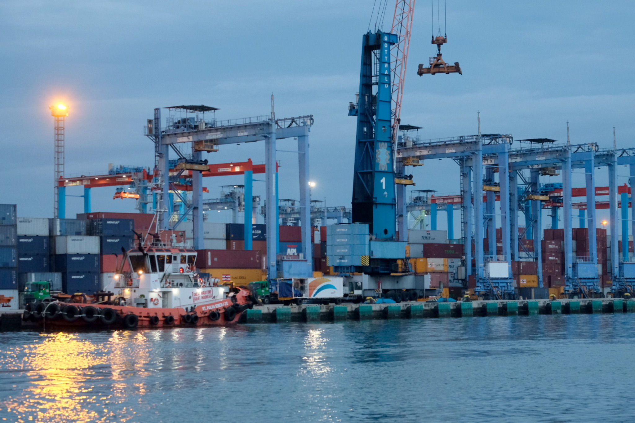 <p>Kapal bersandar didekat crane bongkar muat peti kemas di dermaga Pelabuhan Tanjung Priok, Jakarta, Senin, 11 Januari 2021. Foto: Ismail Pohan/TrenAsia</p>
