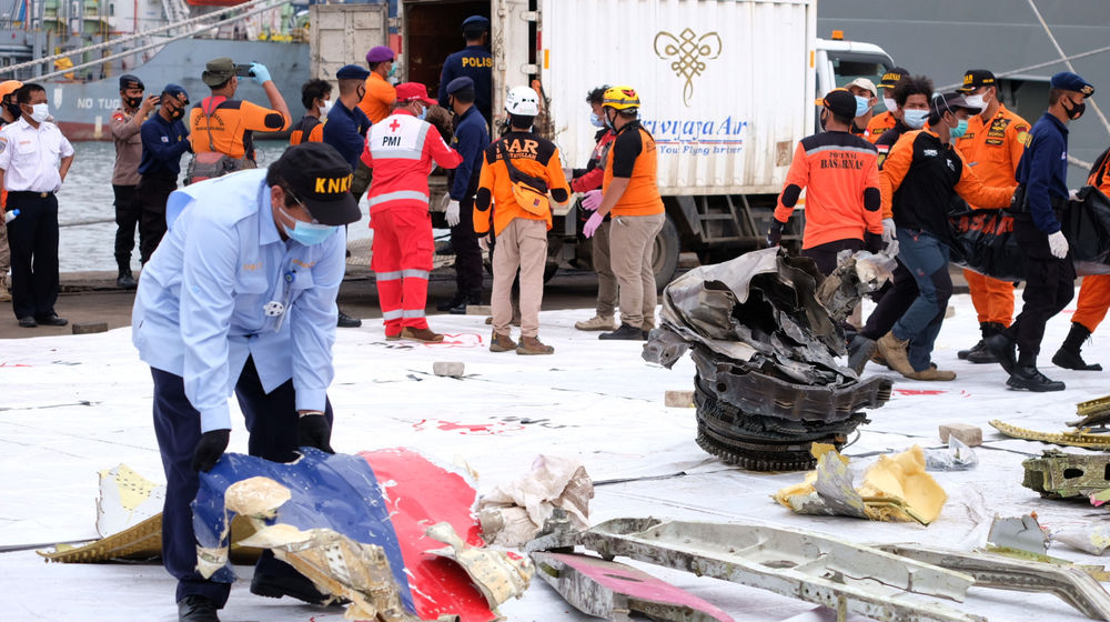 <p>Petugas Komite Nasional Keselamatan Transportasi (KNKT) memeriksa serpihan pesawat Sriwijaya Air SJ 182 yang berhasil di evakuasi dari lokasi pencarian jatuhnya pesawat di perairan Kepulauan Seribu di dermaga JICT 2, Tanjung Priok, Jakarta, Senin, 11 Januari 2021. Foto: Ismail Pohan/TrenAsia</p>
