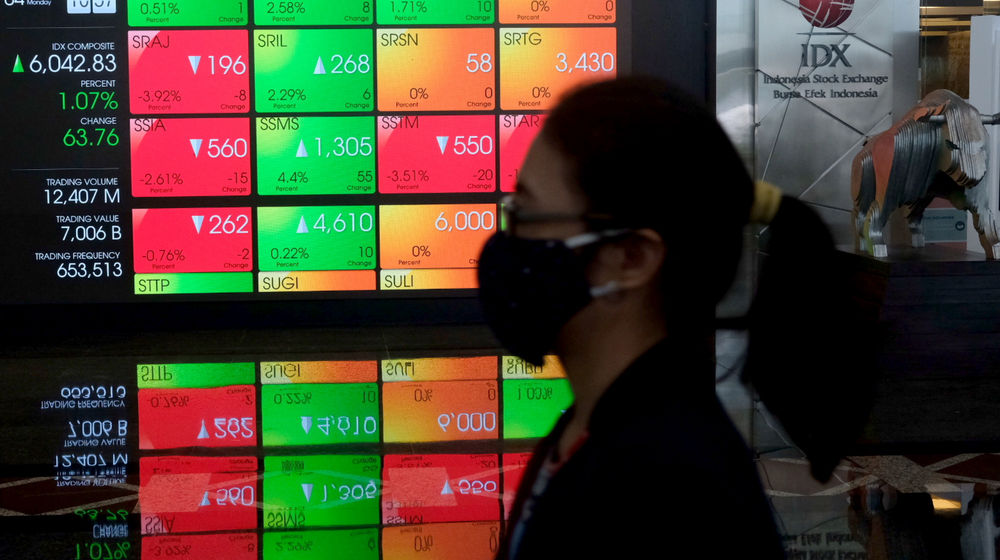 <p>Karyawan melintas dengan latar belakang layar pergerakan Indeks Harga Saham Gabungan (IHSG) di gedung Bursa Efek Indonesia (BEI), Jakarta, Senin, 4 Januari 2021. Foto: Ismail Pohan/TrenAsia</p>