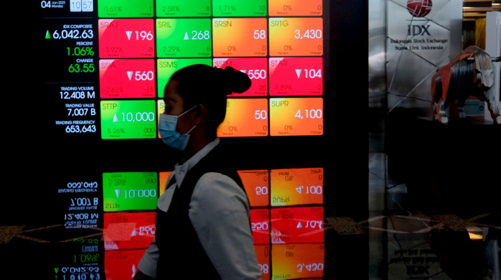 <p>Karyawan melintas dengan latar belakang layar pergerakan Indeks Harga Saham Gabungan (IHSG) di Gedung Bursa Efek Indonesia (BEI), Jakarta, Senin, 4 Januari 2021. Foto: Ismail Pohan/TrenAsia</p>