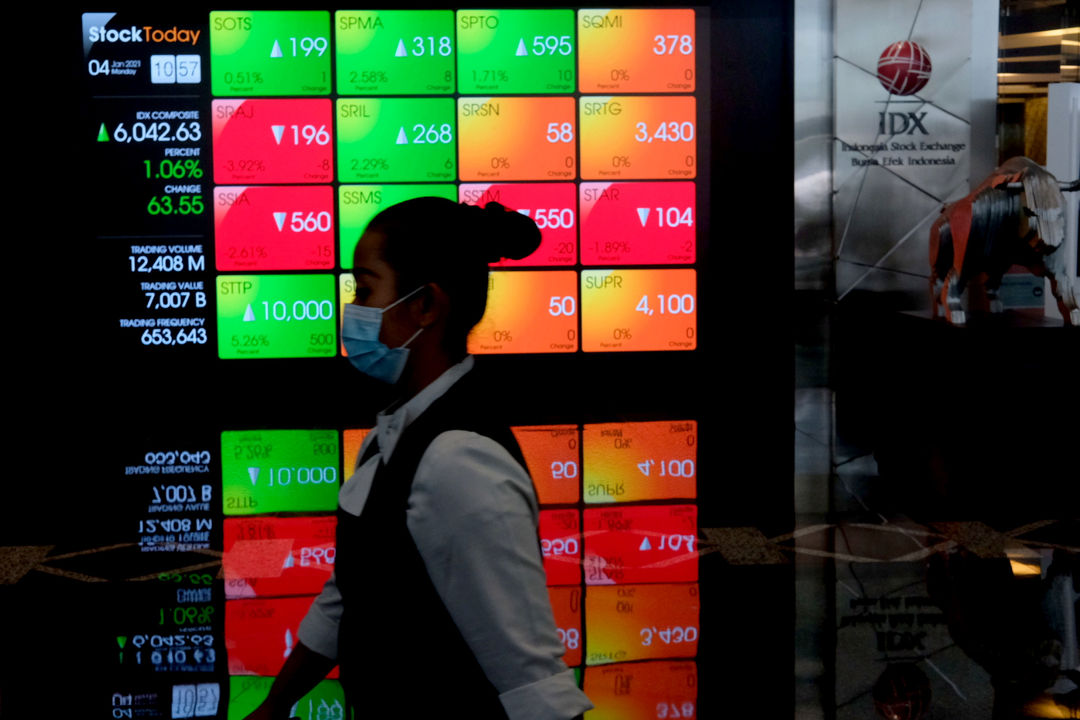 <p>Karyawan melintas dengan latar belakang layar pergerakan Indeks Harga Saham Gabungan (IHSG) di Gedung Bursa Efek Indonesia (BEI), Jakarta, Senin, 4 Januari 2021. Foto: Ismail Pohan/TrenAsia</p>
