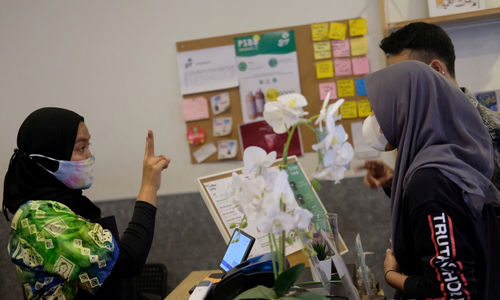 <p>Barista Meir (25), melayani pengunjung menggunakan bahasa isyarat di kafe Sunyi “House of Coffee and Hope” di Jalan Fatmawati, Jakarta, Jum’at, 15 Januari 2021. Foto: Ismail Pohan/TrenAsia</p>