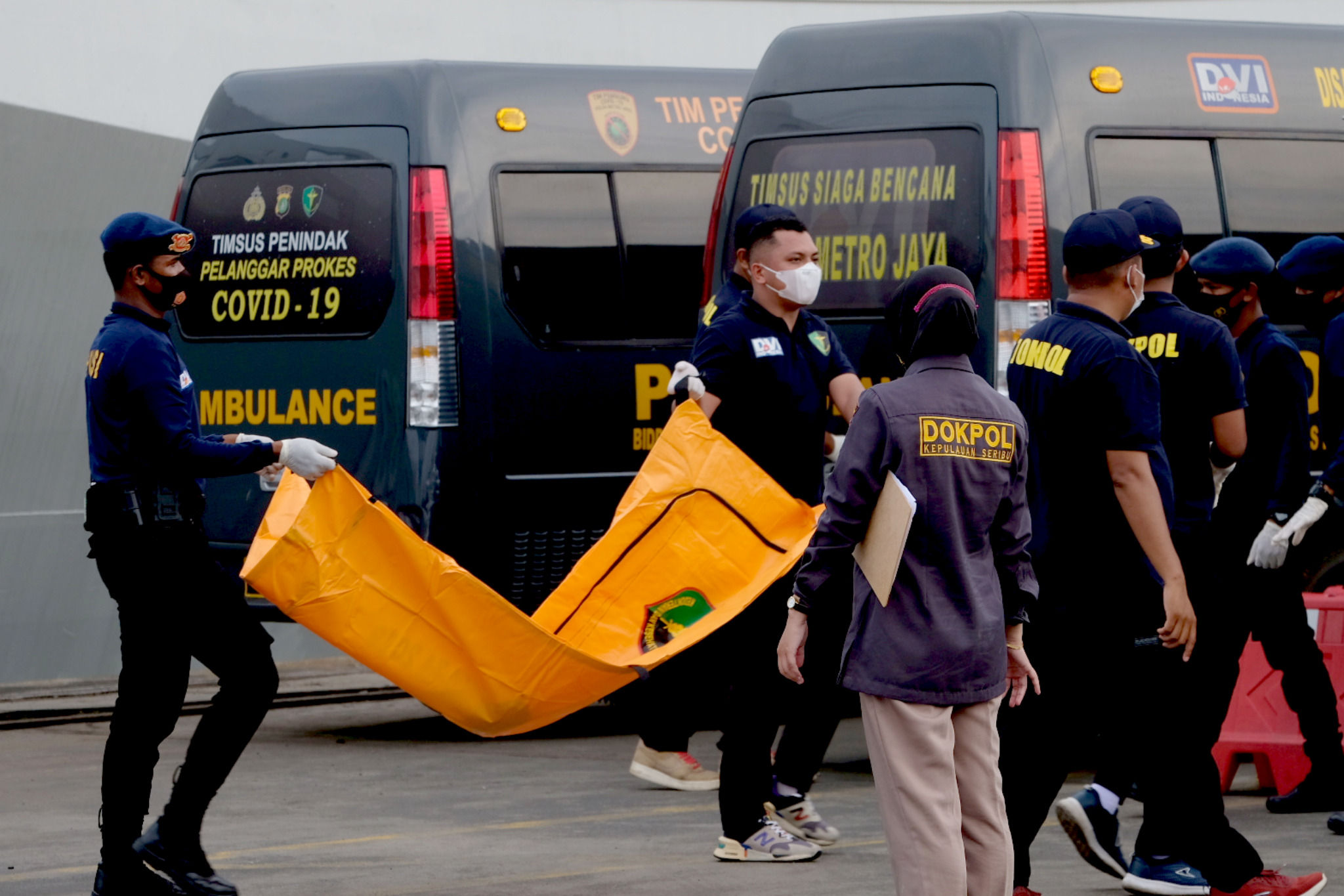 <p>Tim DVI Polri membawa kantong yang berisi potongan jenazah korban jatuhnya pesawat Sriwijaya Air SJ 182 untuk diserahkan ke RS Polri dari posko evakuasi Dermaga JICT 2, Tanjung Priok, Jakarta Utara, Senin, 11 Januari 2021. Foto: Ismail Pohan/TrenAsia</p>
