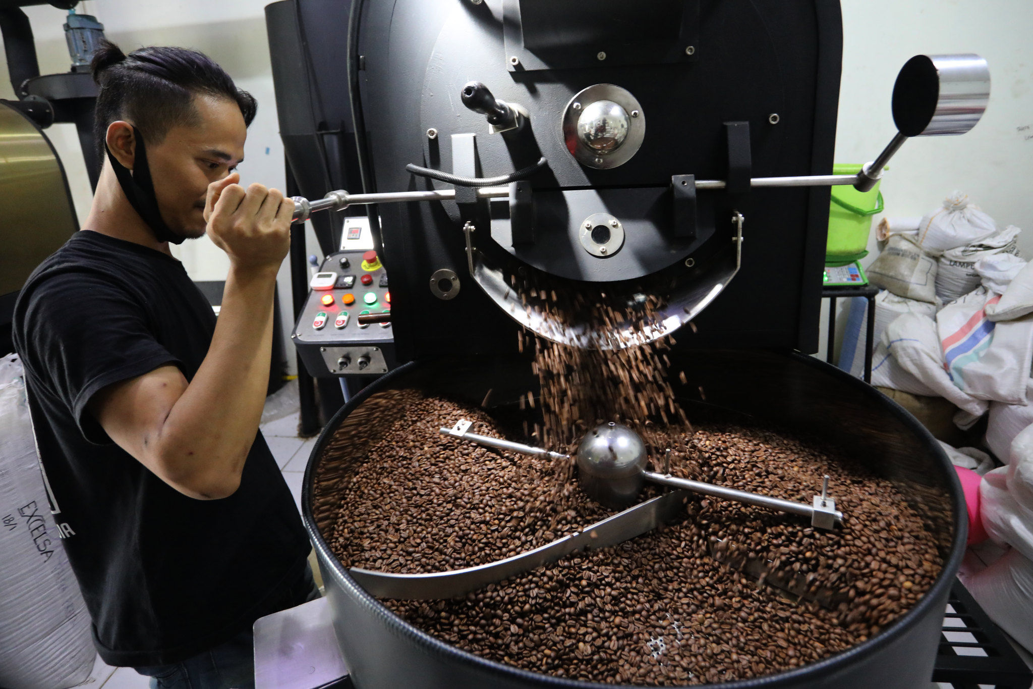 <p>Pekerja melakukan roasting biji kopi dengan mesin di Kedai Dunia Kopi, Pasar Santa, Jakarta Selatan, Selasa, 19 Januari 2021. Foto: Ismail Pohan/TrenAsia</p>
