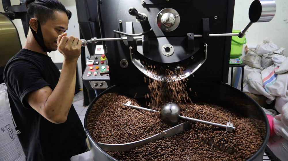 <p>Pekerja melakukan roasting biji kopi dengan mesin di Kedai Dunia Kopi, Pasar Santa, Jakarta Selatan, Selasa, 19 Januari 2021. Foto: Ismail Pohan/TrenAsia</p>
