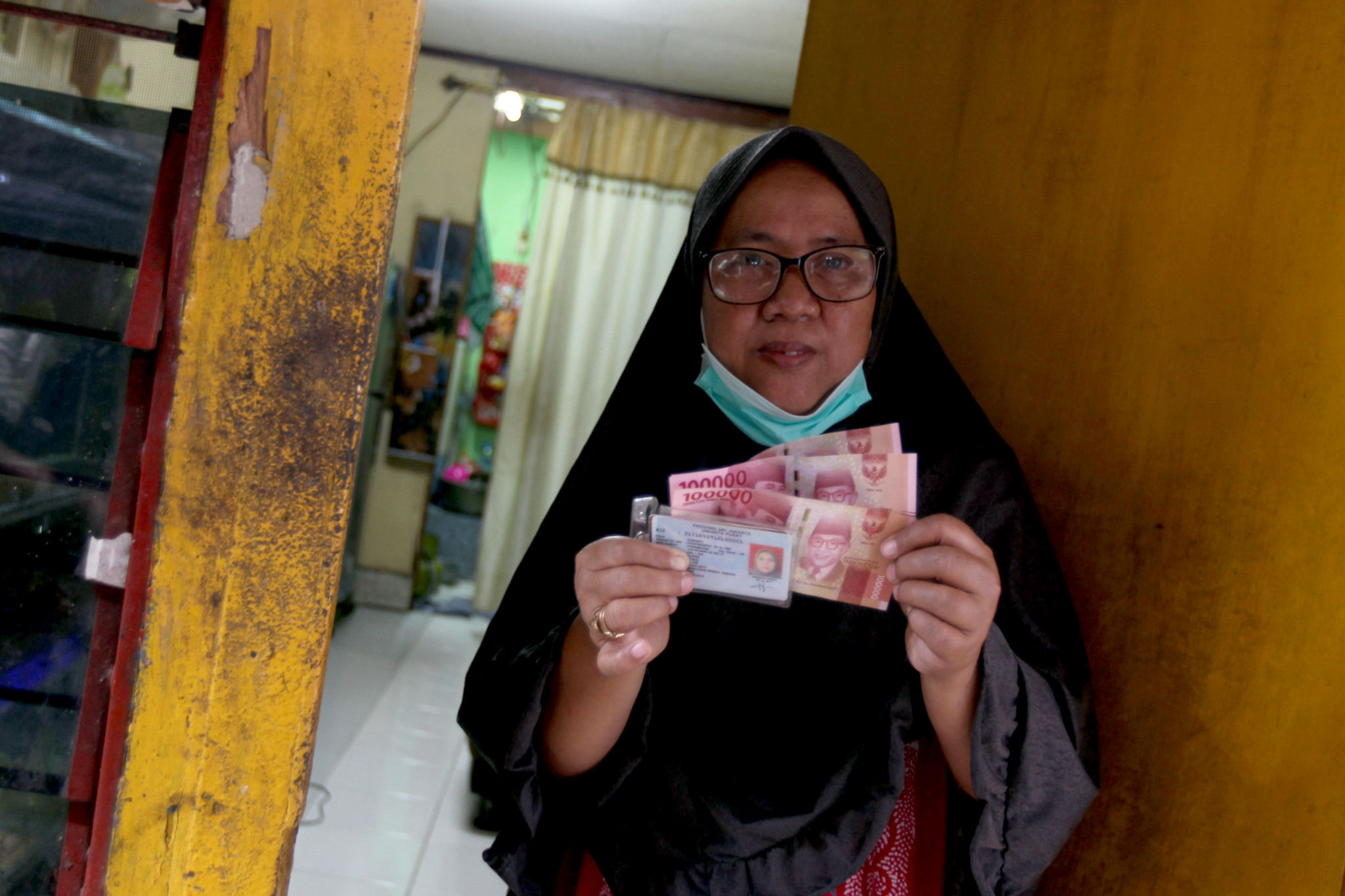<p>Warga RW 05 penerima Bantuan Sosial Tunai (BST) menunjukkan uang yang diterimanya di kawasan Kelurahan Kenari, Senen, Jakarta, Rabu, 6 Januari 2021. Foto: Ismail Pohan/TrenAsia</p>
