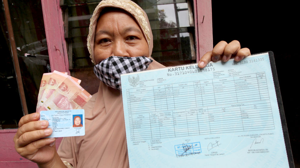 <p>Warga RW 05 penerima Bantuan Sosial Tunai (BST) menunjukkan dokumen persyaratan dan uang yang telah diterima di kawasan Kelurahan Kenari, Senen, Jakarta, Rabu, 6 Januari 2021. Foto: Ismail Pohan/TrenAsia</p>
