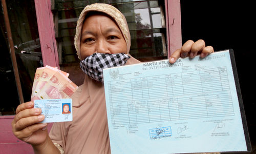 <p>Warga RW 05 penerima Bantuan Sosial Tunai (BST) menunjukkan dokumen persyaratan dan uang yang telah diterima di kawasan Kelurahan Kenari, Senen, Jakarta, Rabu, 6 Januari 2021. Foto: Ismail Pohan/TrenAsia</p>
