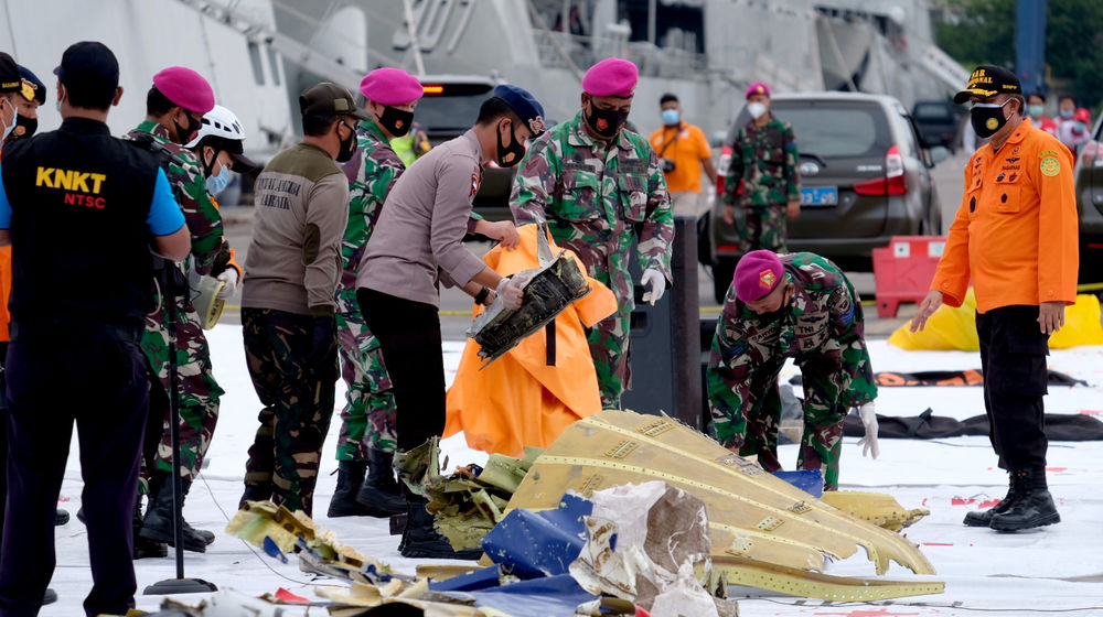 <p>Petugas gabungan meletakkan serpihan pesawat di Posko Evakuasi jatuhnya pesawat Sriwijaya Air SJ182 rute Jakarta – Pontianak di Dermaga JICT, Tanjung Priok, Jakarta Utara, Minggu, 10 Januari 2021. Foto: Ismail Pohan/TrenAsia</p>
