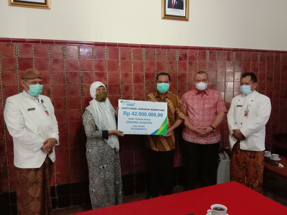 Walikota Surakarta FX Hadi Rudyatmo didampingi Kepala Cabang BPJS Ketenagakerjaan Surakarta Hasan Fahmi menyerahkan santunan kematian untuk peserta driver ojek online