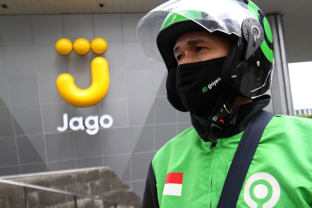 Mitra Driver Gojek menunggu customer di dekat logo Bank Jago di kawasan Mega Kuningan, Jakarta, Selasa, 16 Februari 2021. Foto: Panji Asmoro/TrenAsia