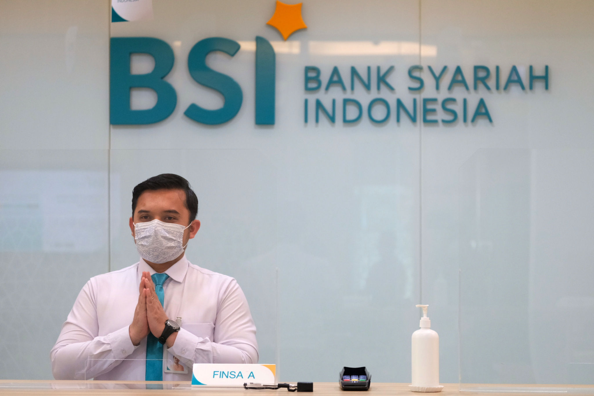 <p>Karyawan memberikan salam kepada nasabah di kantor cabang Bank Syariah Indonesia (BRIS) Jakarta Hasanudin, Jakarta, Rabu, 17 Februari 2021. Foto: Ismail Pohan/TrenAsia</p>
