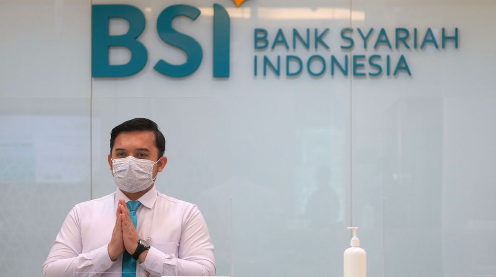 <p>Karyawan memberikan salam kepada nasabah di kantor cabang Bank Syariah Indonesia (BRIS) Jakarta Hasanudin, Jakarta, Rabu, 17 Februari 2021