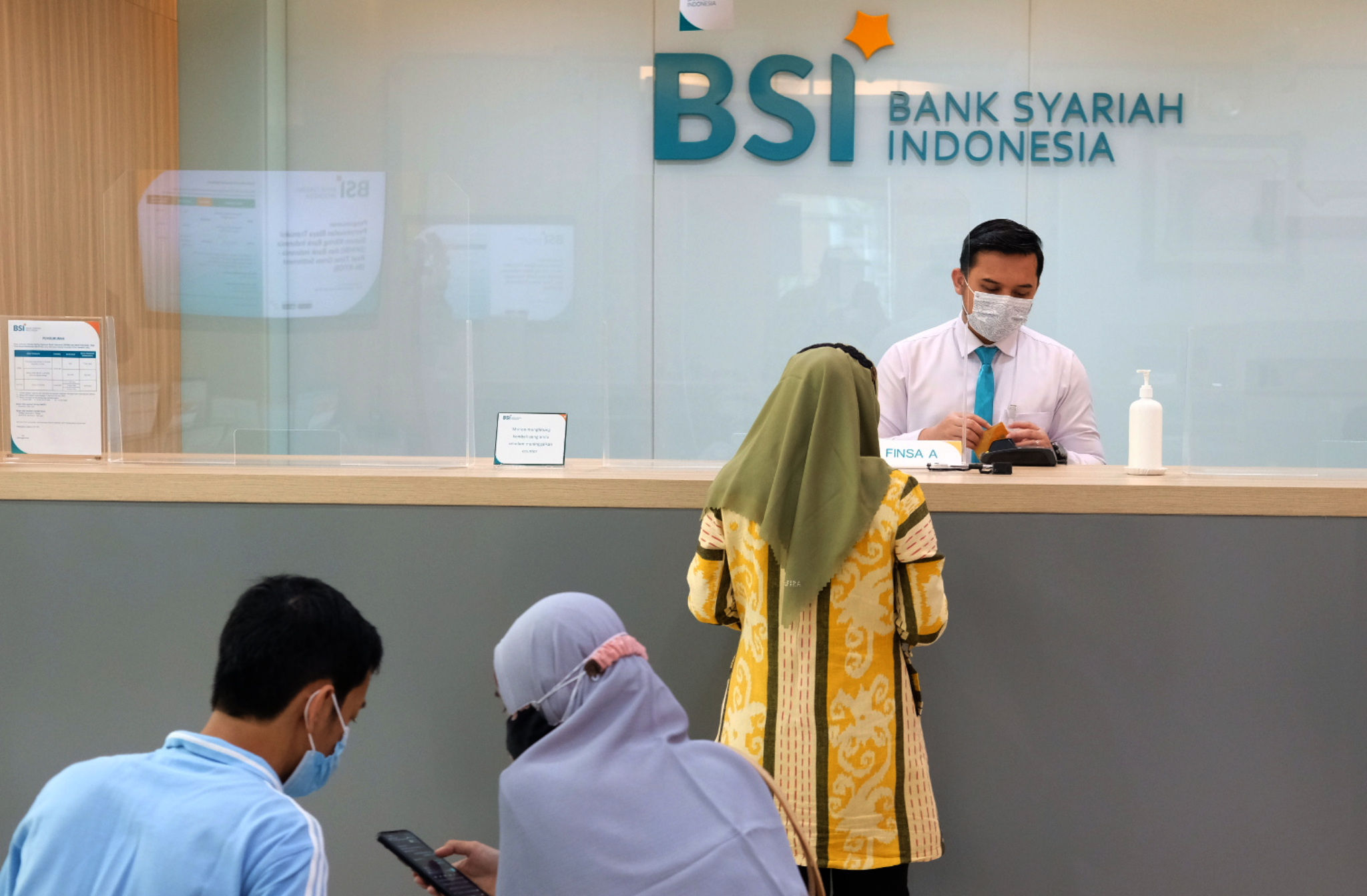 Karyawan melayani nasabah di kantor cabang Bank Syariah Indonesia (BRIS) Jakarta Hasanudin, Jakarta, Rabu, 17 Februari 2021. Foto: Ismail Pohan/TrenAsia</p>
