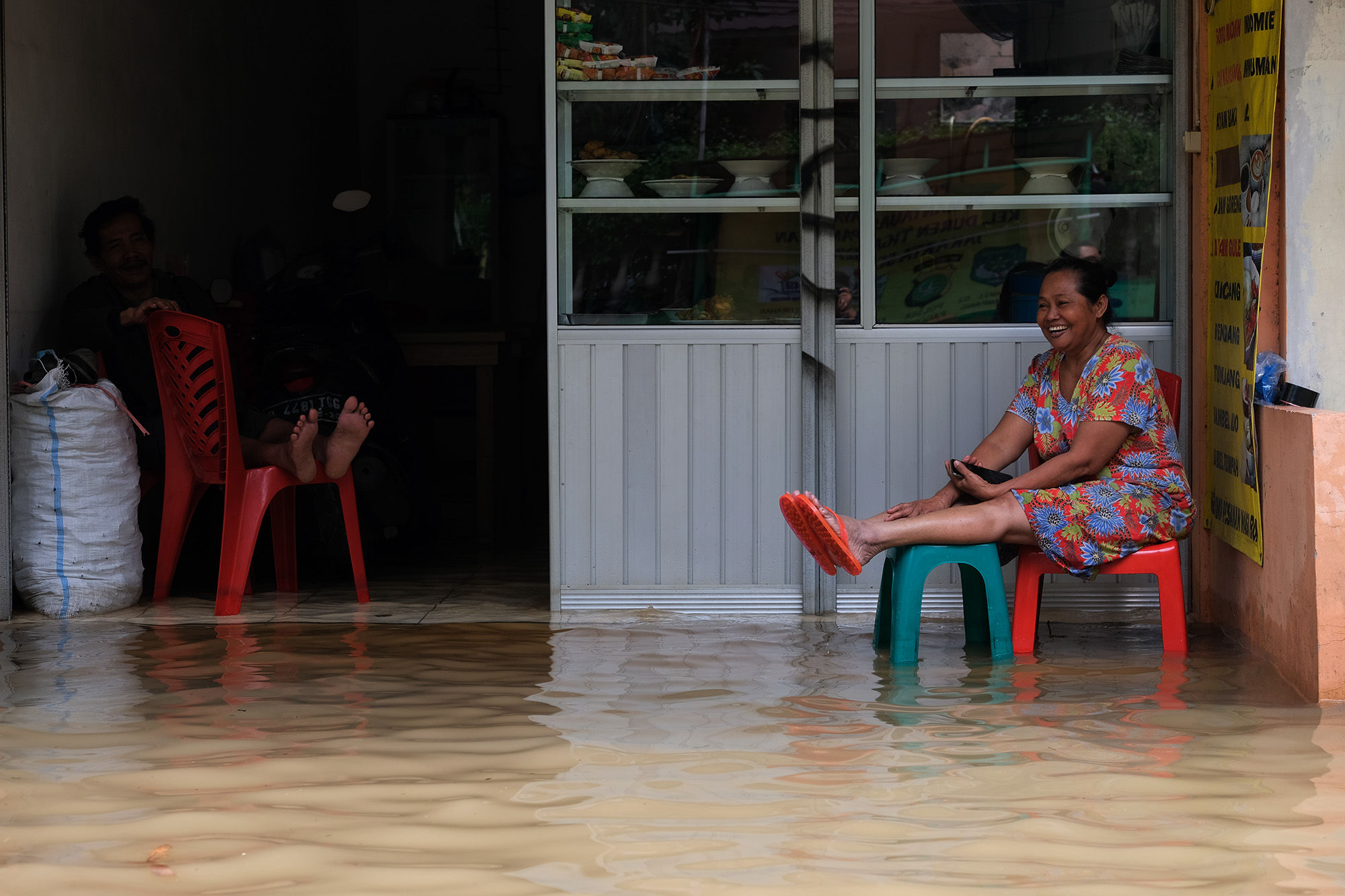 <p>Warga bersantai di depan warungnya saat banjir yang menggenangi kawasan Kemang Utara, Jakarta, Sabtu, 20 Februari 2021. Foto: ismail Pohan/TrenAsia</p>
