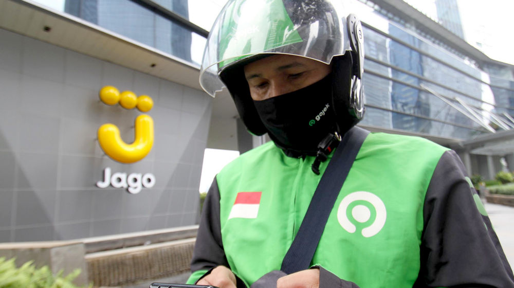<p>Mitra Driver Gojek menunggu customer di dekat logo Bank Jago di kawasan Mega Kuningan, Jakarta, Selasa, 16 Februari 2021. Foto: Panji Asmoro/TrenAsia</p>
