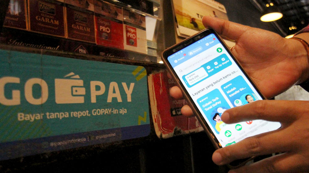 <p>Warga tengah melakukan transaksi pembayaran dengan menggunakan aplikasi Gopay di kawasan Tangerang. Foto: Panji Asmoro/TrenAsia</p>
