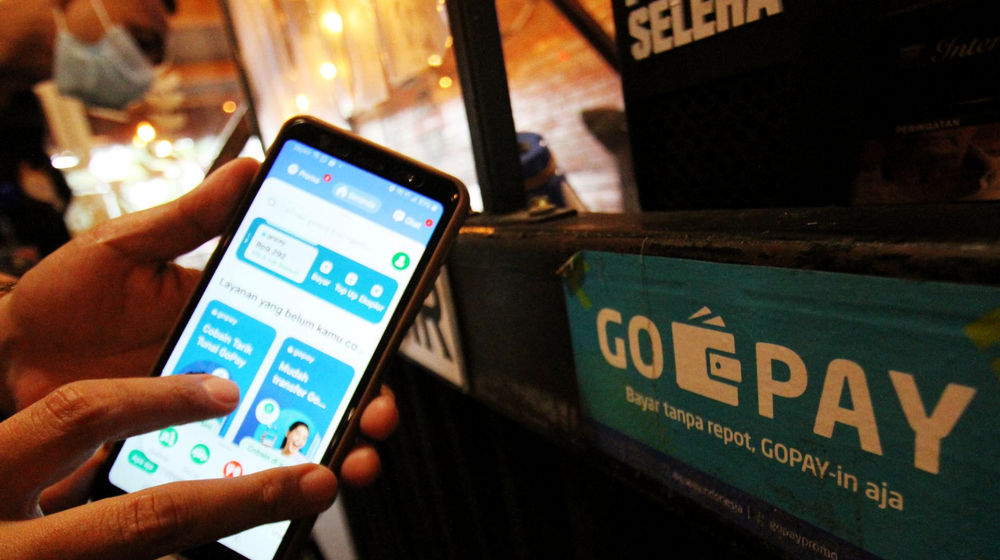 Warga tengah melakukan transaksi pembayaran dengan menggunakan aplikasi Gopay di kawasan Tangerang. 