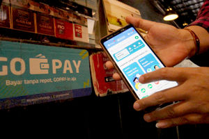 <p>Warga tengah melakukan transaksi pembayaran dengan menggunakan aplikasi Gopay di kawasan Tangerang. Foto: Panji Asmoro/TrenAsia</p>
